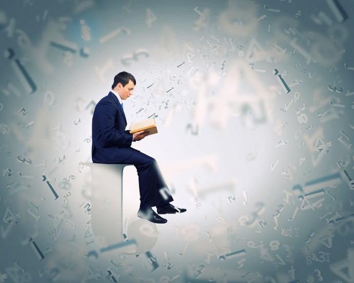 Man reading book surrounded by falling letters