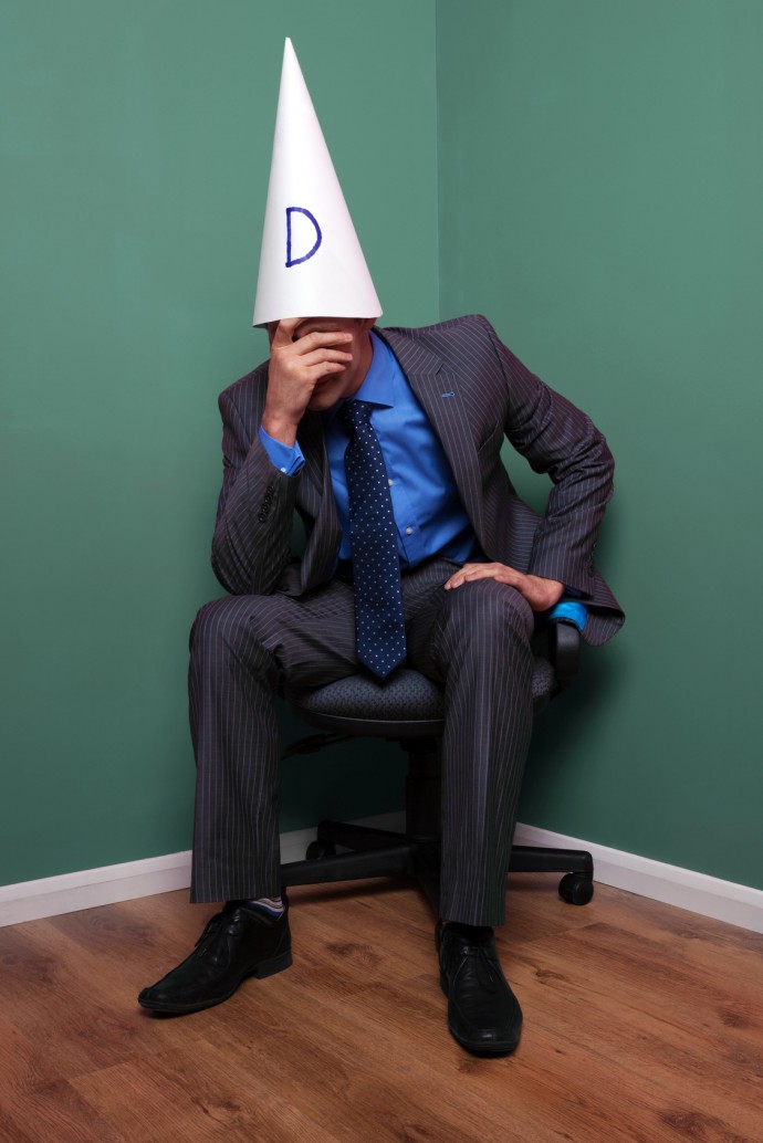 Businessman wearing a dunce hat